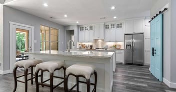 Image of a custom kitchen with island seating, custom cabinets, and sliding door by Wonderview Custom Homes