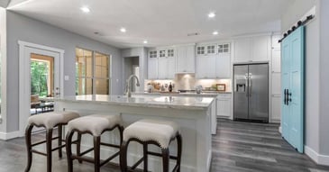 Image of a custom kitchen with island seating, custom cabinets, and sliding door by Wonderview Custom Homes