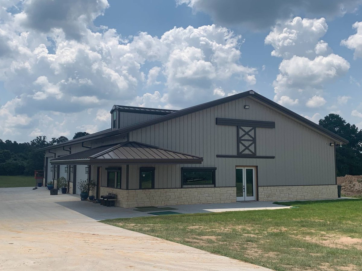 Angled exterior view of a Wonderview Home Services residential barndominium in Navasota, TX with covered entry and metal roof.-optimized