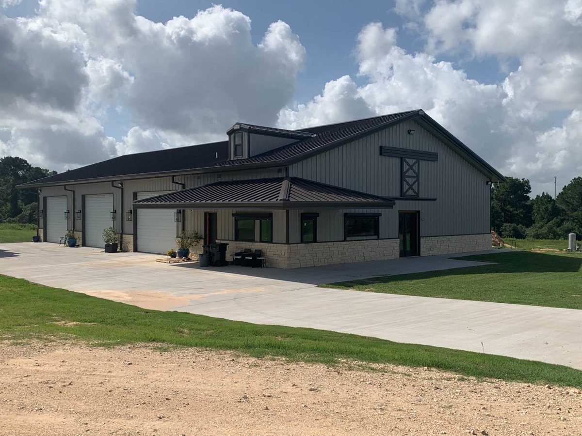 Exterior front view of a Wonderview Home Services residential barndominium in Navasota, TX with multiple garage bays.-optimized