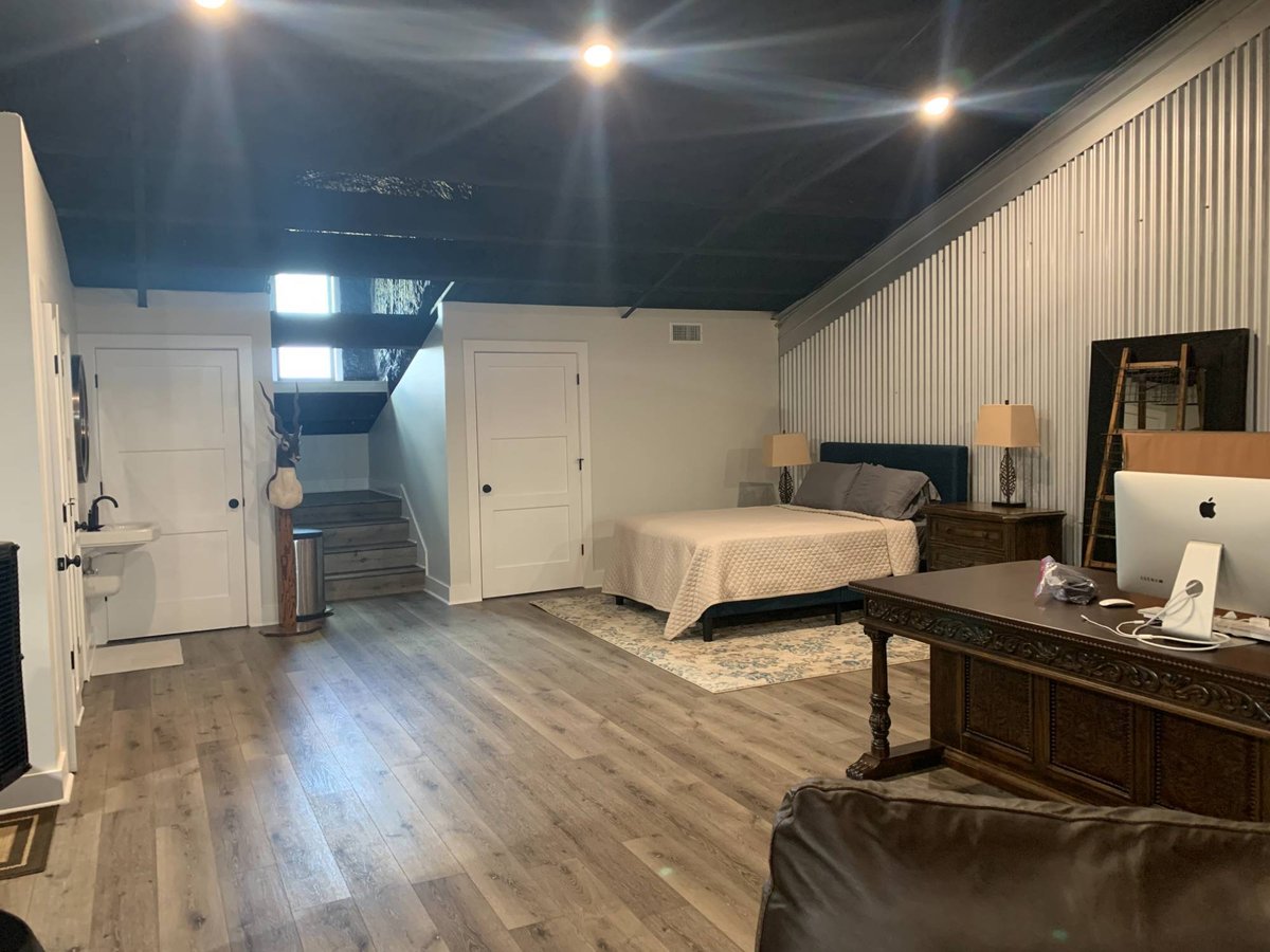 Spacious barndominium interior by Wonderview Home Services in Navasota, Texas with wood flooring and loft staircase.-optimized