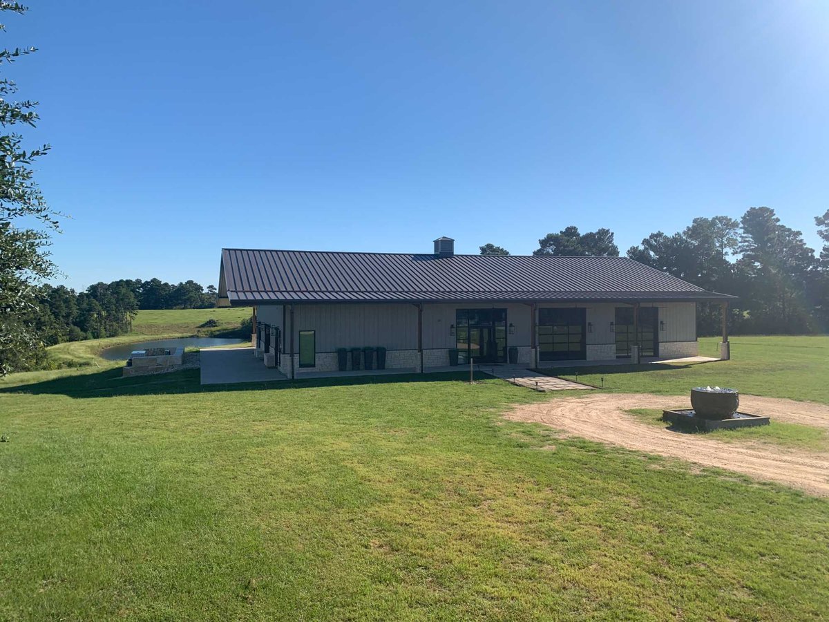 Modern commercial building with metal roof and landscaped grounds by Wonderview Home Services in Navasota, TX.-optimized