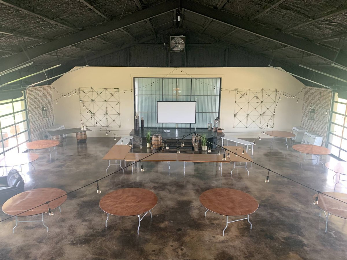 Open commercial gathering space with string lighting and polished concrete floors by Wonderview Home Services in Navasota, TX.-optimized