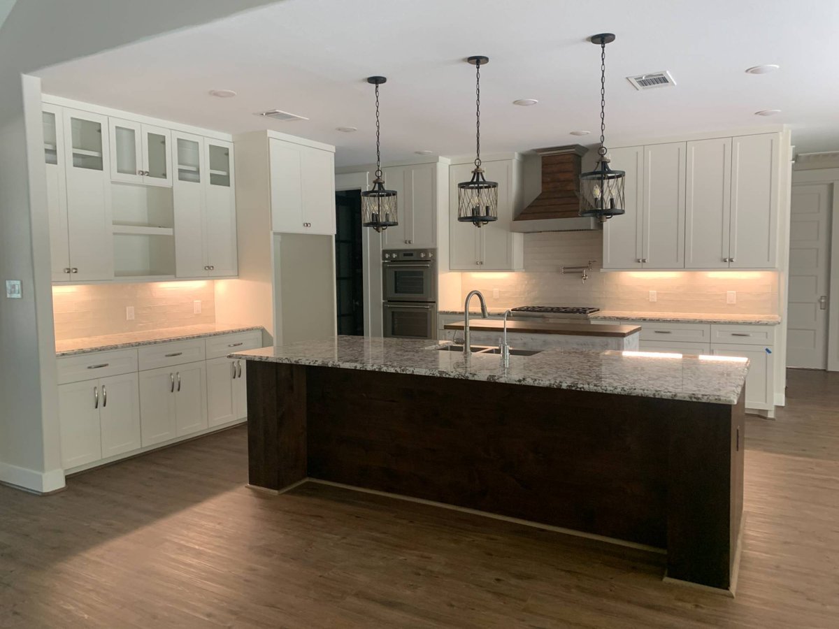 Magnolia, Texas residential new construction kitchen featuring custom white cabinets by Wonderview Home Services.-optimized