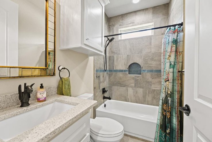 Bright custom home bathroom with granite vanity and tiled bathtub surround by Wonderview Home Services in Magnolia, TX.-optimized