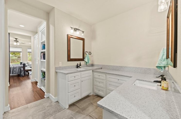 Double vanity bathroom with quartz countertops in a custom home by Wonderview Home Services in Magnolia, TX.-optimized