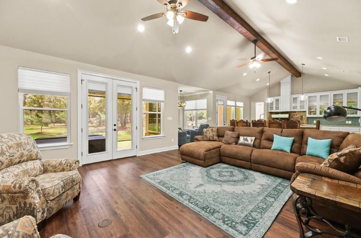 Open-concept living room in a custom home by Wonderview Home Services with vaulted ceilings in Magnolia, TX.-optimized