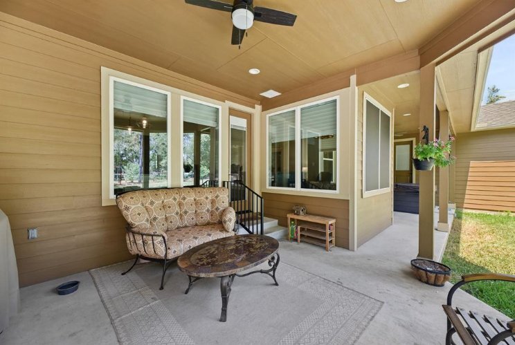 Outdoor entertaining space with cushioned seating and ceiling fan by Wonderview Home Services in Magnolia, TX.-optimized