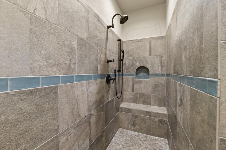Walk-in tiled shower with built-in niche in a custom home by Wonderview Home Services in Magnolia, TX.-optimized