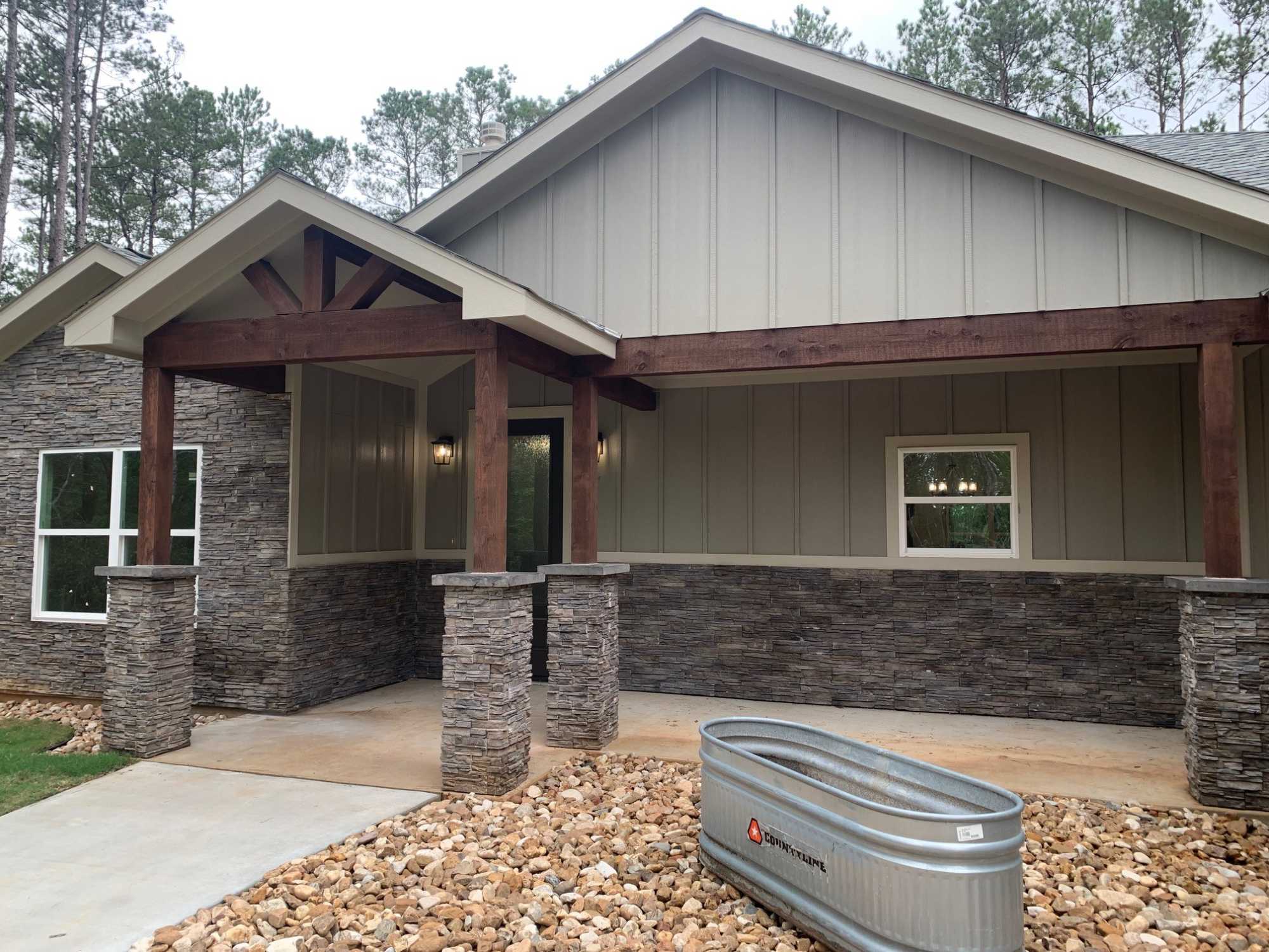 Front porch exterior of a residential new construction home by Wonderview Home Services in Magnolia, TX with stone columns and w-optimized