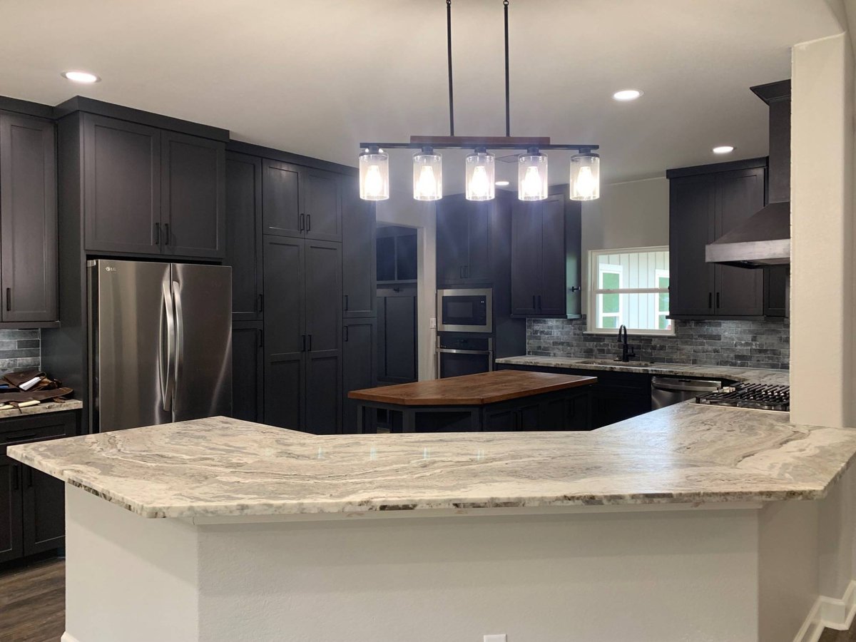 Luxury kitchen interior with black cabinets and stainless steel appliances by Wonderview Home Services in Magnolia, TX.-optimized
