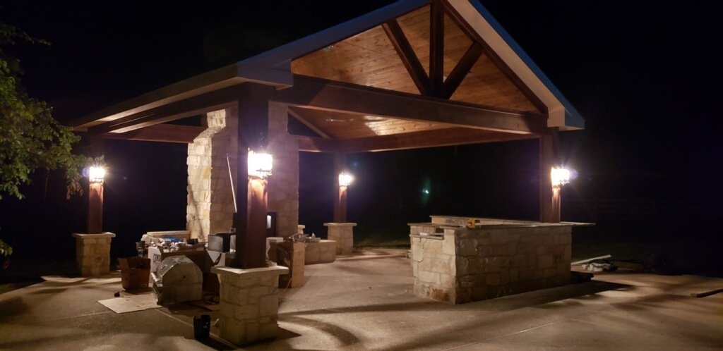 Backyard patio construction with exposed wood beams and outdoor kitchen by Wonderview Home Services in Montgomery, TX.-optimized