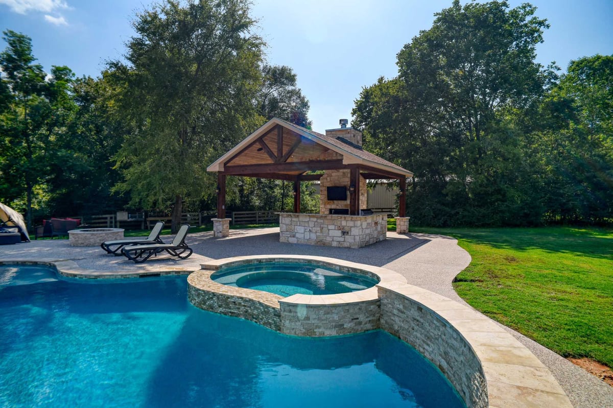 Luxury poolside patio featuring outdoor kitchen and covered entertainment space in Montgomery, TX.-optimized