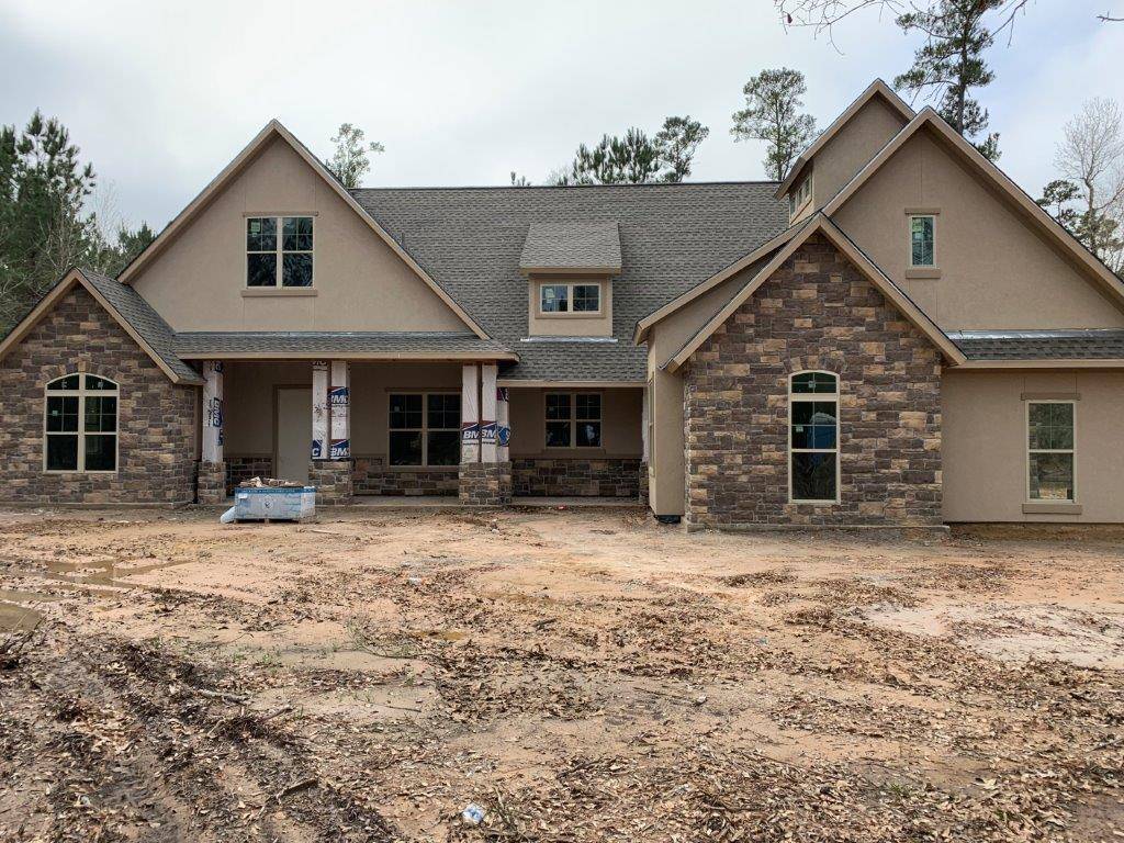Residential new construction home exterior with stone accents by Wonderview Home Services in New Waverly, TX.-optimized
