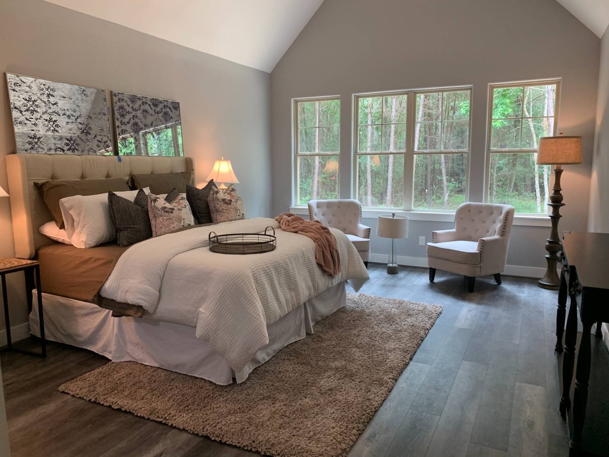 Spacious primary bedroom with vaulted ceilings and large windows in a custom home by Wonderview Home Services in New Waverly, TX-optimized
