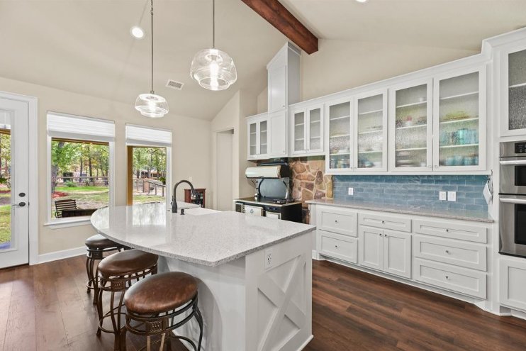 Bright kitchen interior with quartz countertops and pendant lighting in a Magnolia, TX custom home by Wonderview Home Services.-optimized