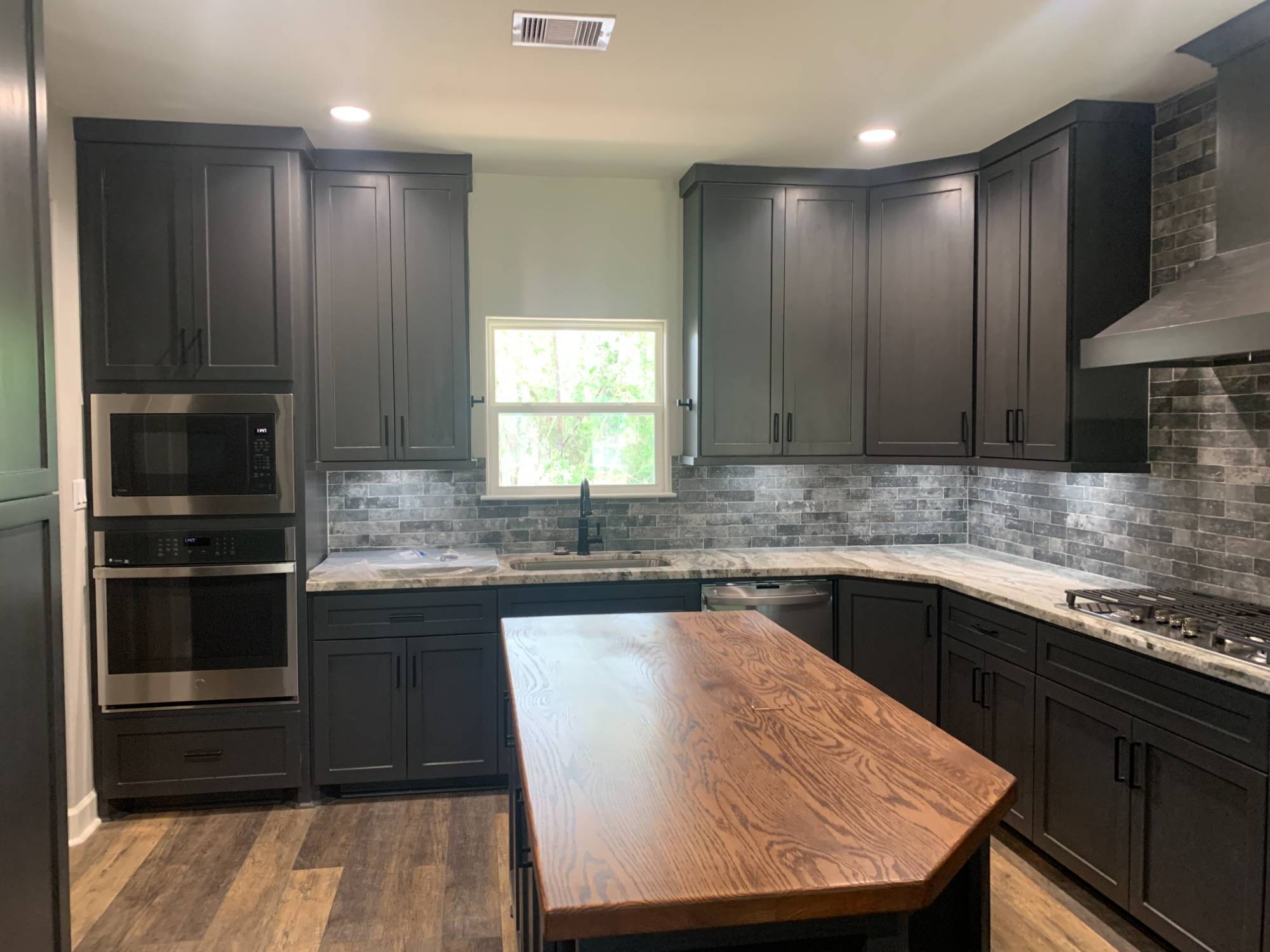 Contemporary custom kitchen with dark shaker cabinets and wood island by Wonderview Home Services in Magnolia, TX.-optimized