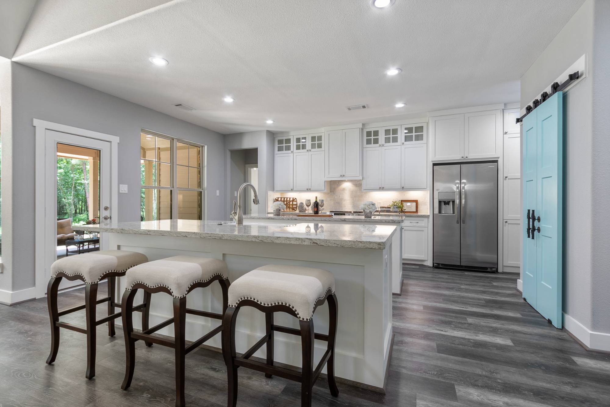 Custom kitchen with oversized island and white cabinetry by Wonderview Home Services in New Waverly, TX.-optimized