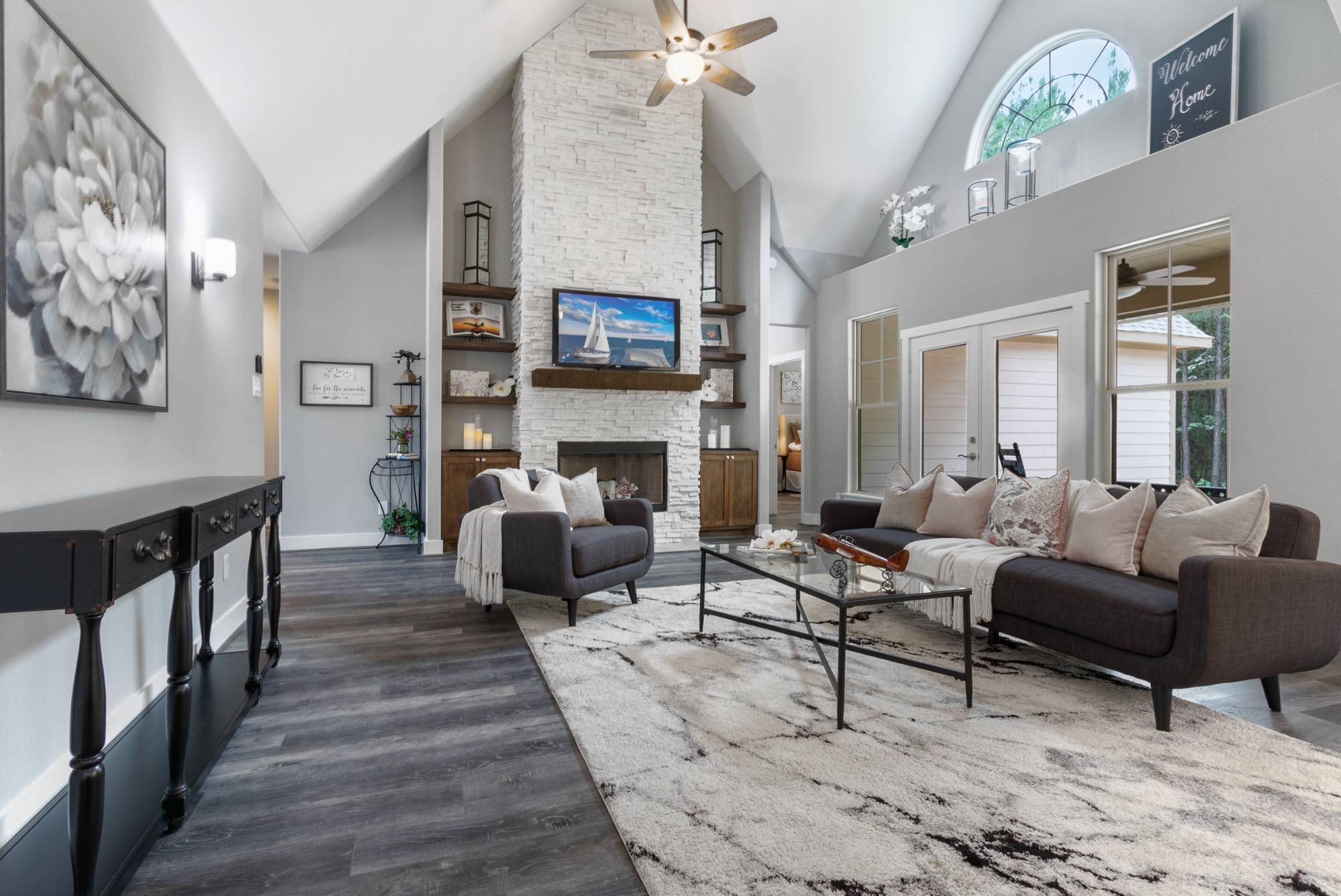 Elegant living room with floor-to-ceiling stone fireplace in a custom home by Wonderview Home Services in New Waverly, TX.-optimized