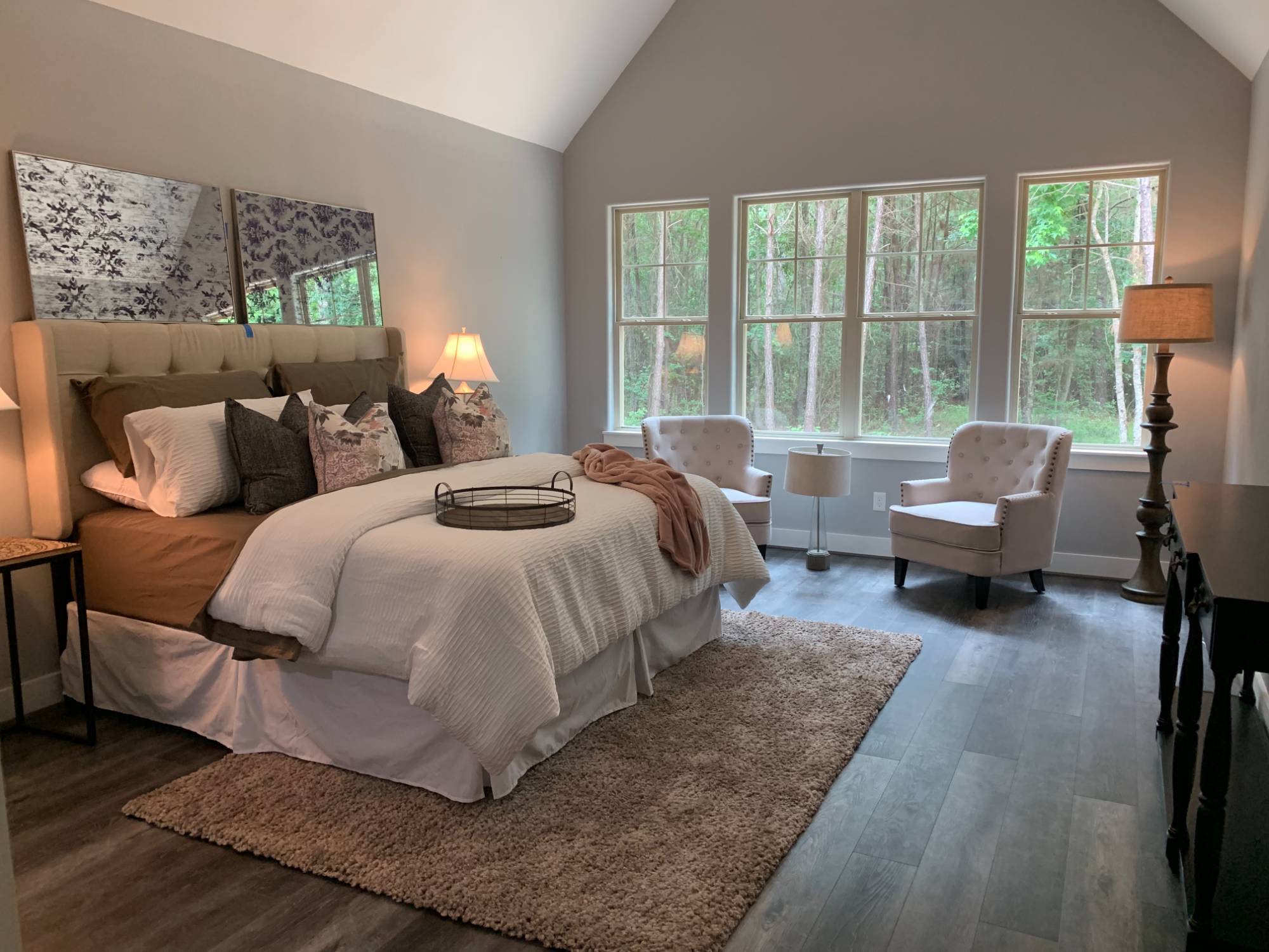 Spacious primary bedroom with vaulted ceilings and large windows in a custom home by Wonderview Home Services in New Waverly, TX-optimized